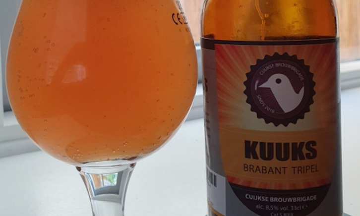 Kuuks Brabant Tripel gevuld glas en flesje op tafel